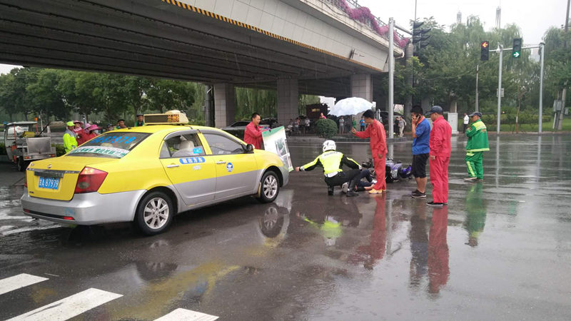 At the scene of the incident, the traffic police sheltered the injured and passers-by held umbrellas for the traffic police.